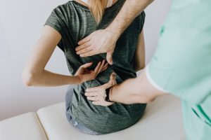 Physiotherapist with patient treating back Physiotherapist with patient treating back
