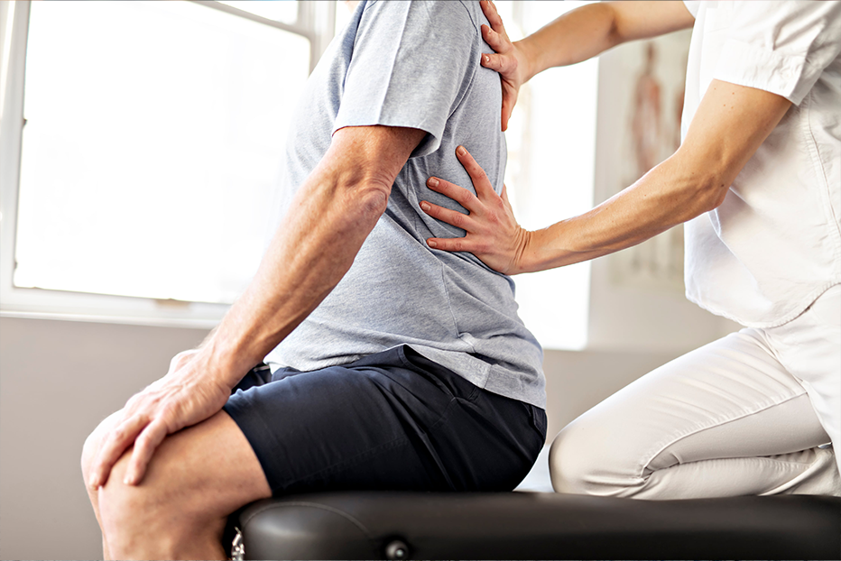 Chiropractor looking at clients back Chiropractor looking at clients back