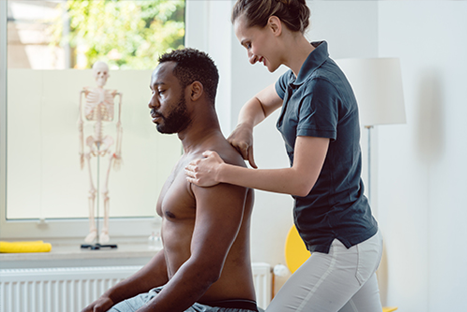 Osteopath looking at clients back Osteopath looking at clients back